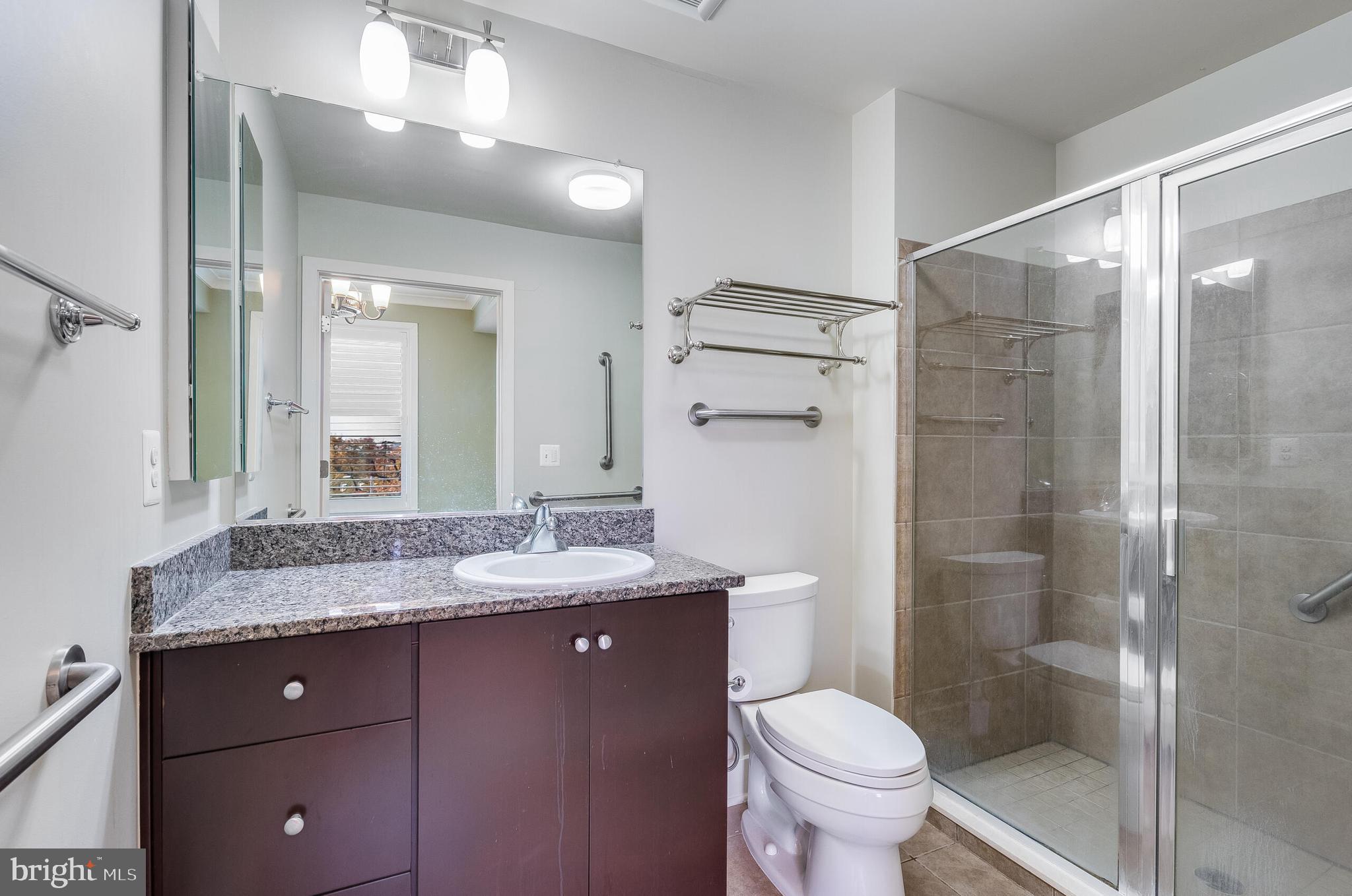 815 North Patrick Street, Unit 402 Alexandria, VA 22314 - Photo 15 of 23 a bathroom with a granite countertop sink toilet and shower