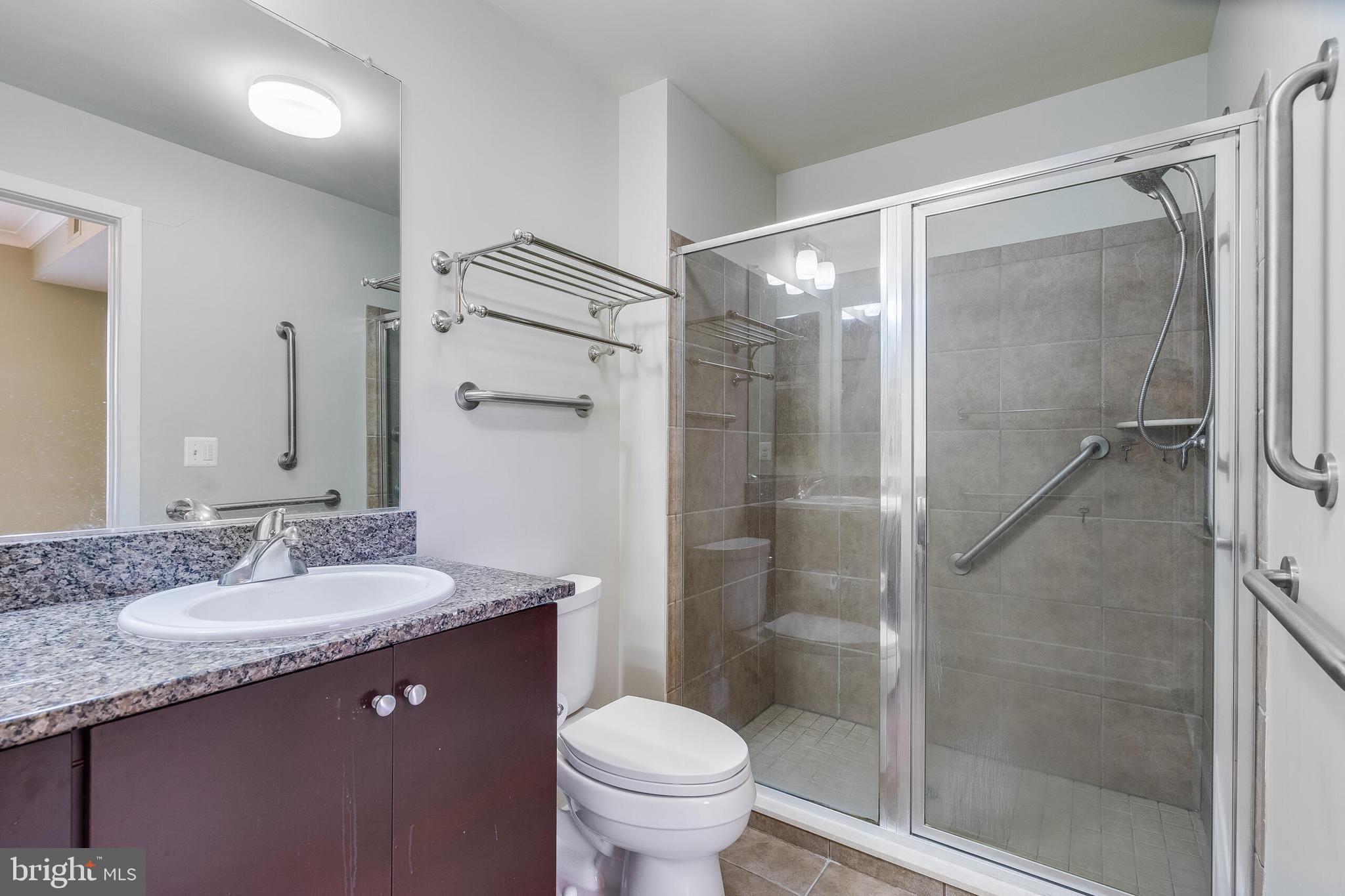 815 North Patrick Street, Unit 402 Alexandria, VA 22314 - Photo 16 of 23 a bathroom with a granite countertop sink toilet and shower