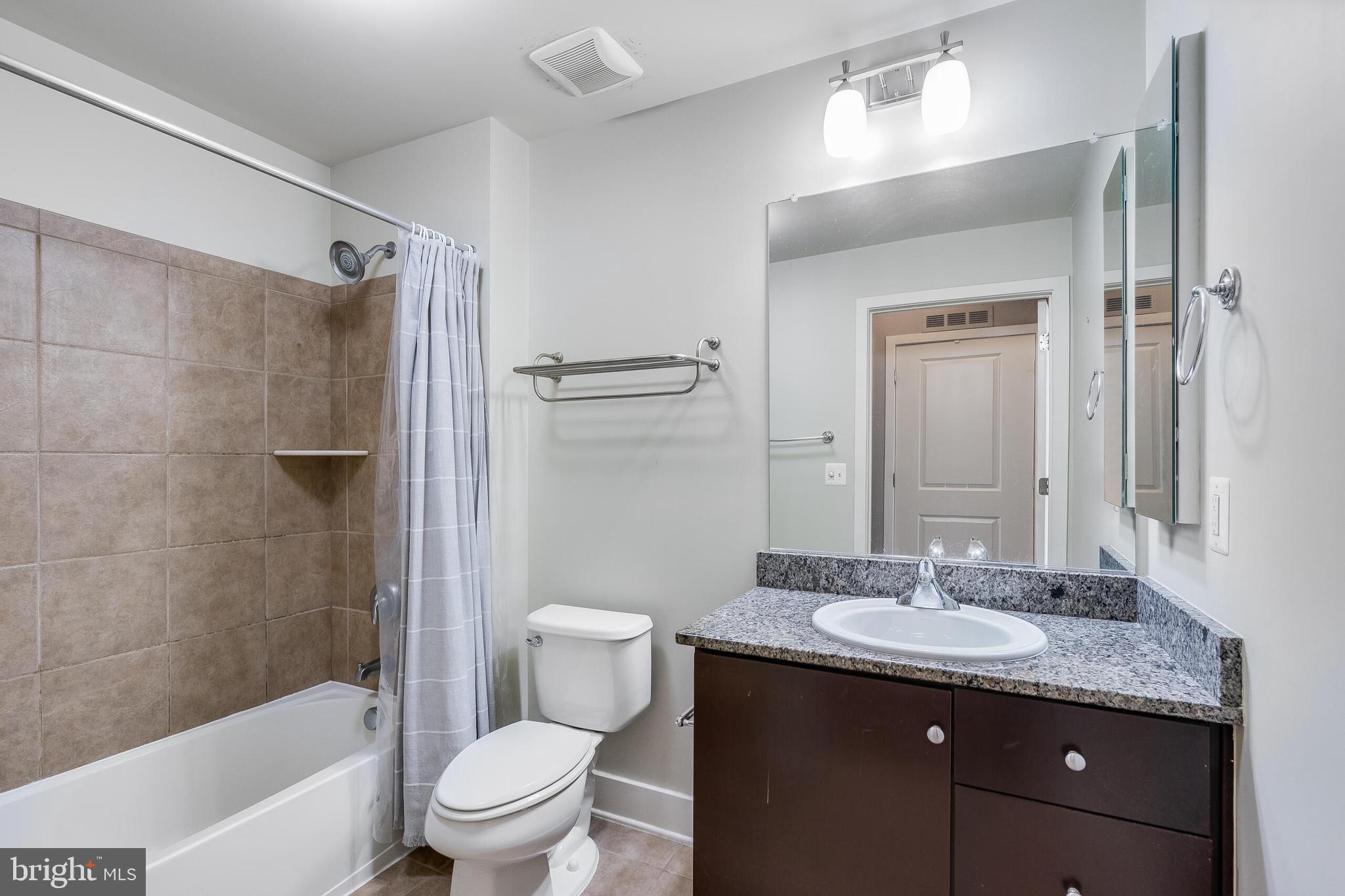 815 North Patrick Street, Unit 402 Alexandria, VA 22314 - Photo 23 of 23 a bathroom with a granite countertop sink toilet and shower