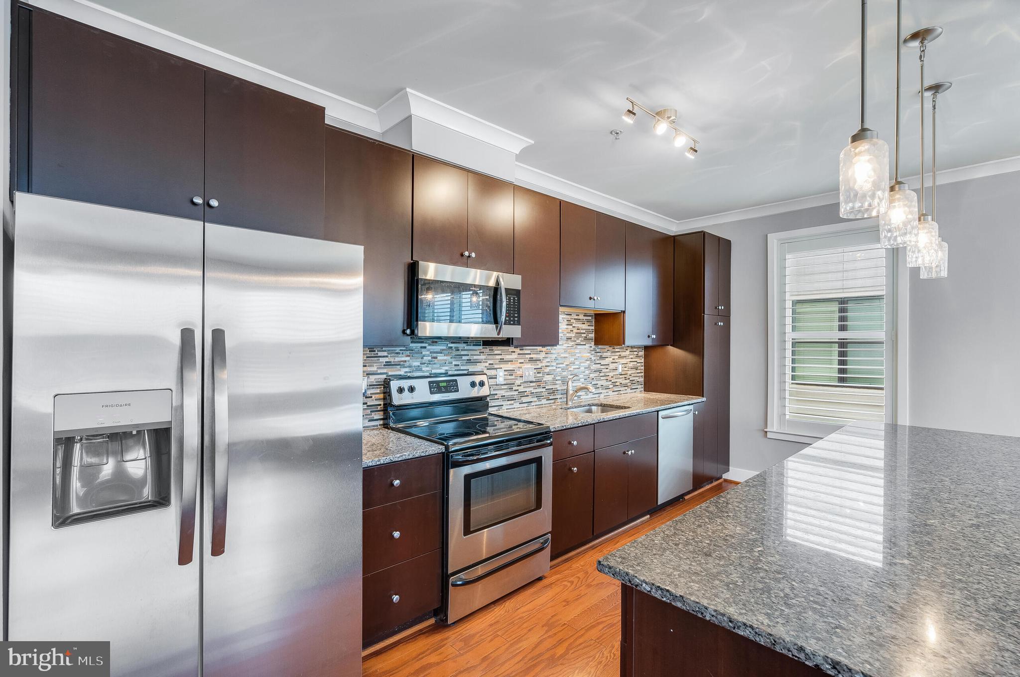 815 North Patrick Street, Unit 402 Alexandria, VA 22314 - Photo 9 of 23 a kitchen with stainless steel appliances granite countertop a stove and a refrigerator