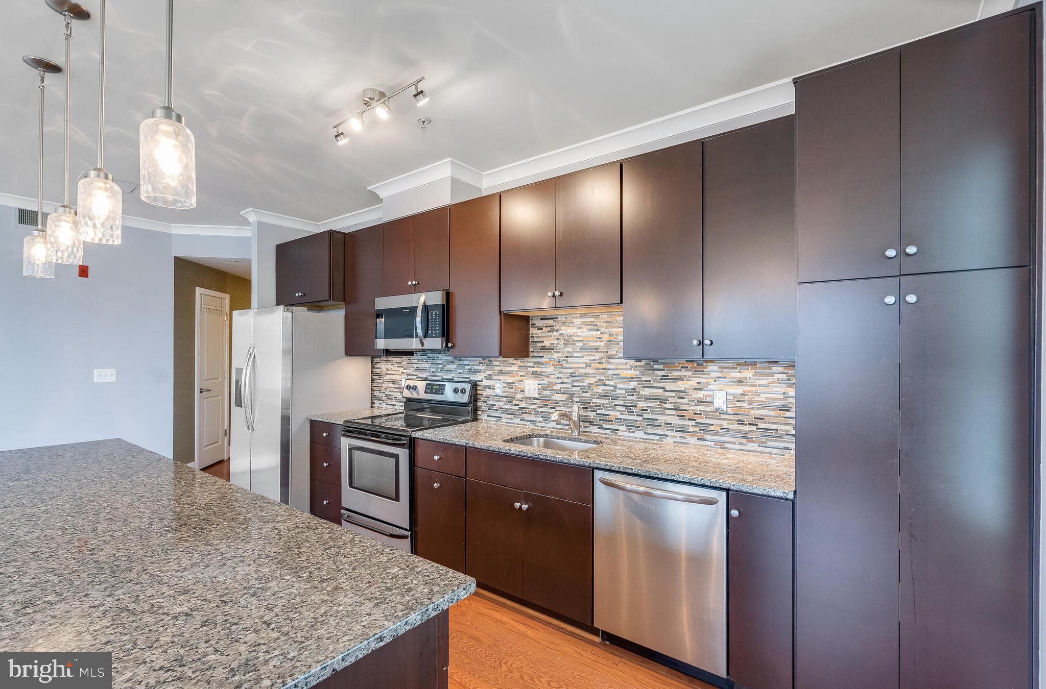 815 North Patrick Street, Unit 402 Alexandria, VA 22314 - Photo 10 of 23 a kitchen with stainless steel appliances granite countertop a stove a sink and a refrigerator
