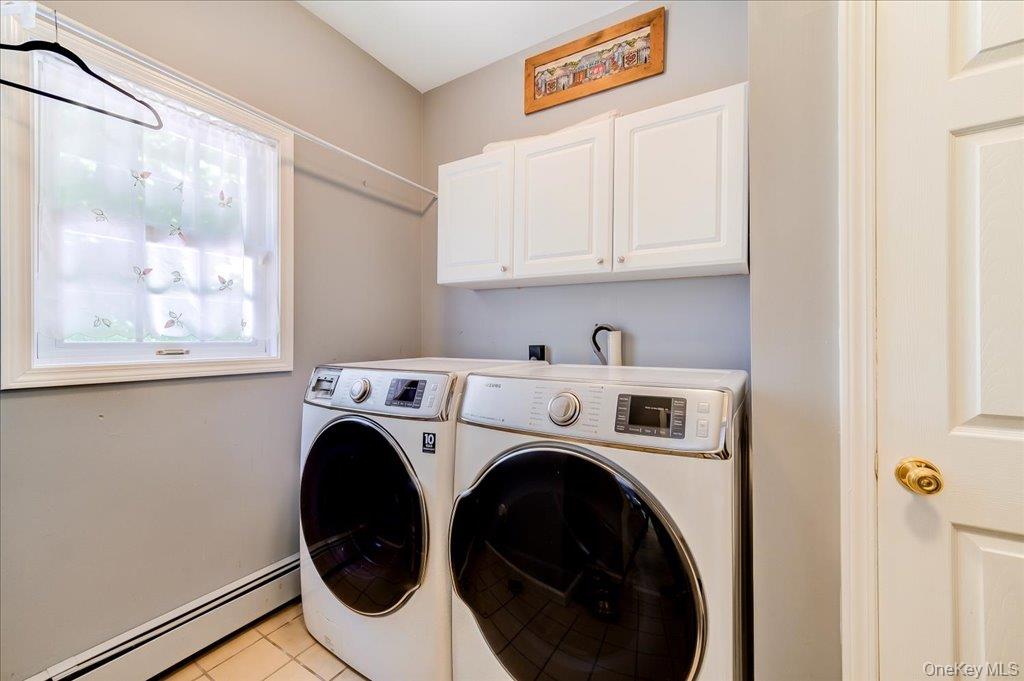 104 Wiccopee Road Putnam Valley, NY 10579 - Photo 19 of 50 Laundry area featuring light gray walls, a single window, white upper cabinetry, and tile flooring