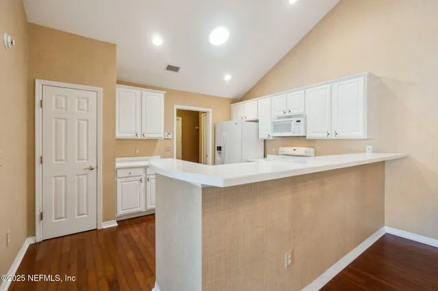 a view of a room with wooden floor and chandelier