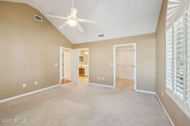a view of a white house next to a yard and road