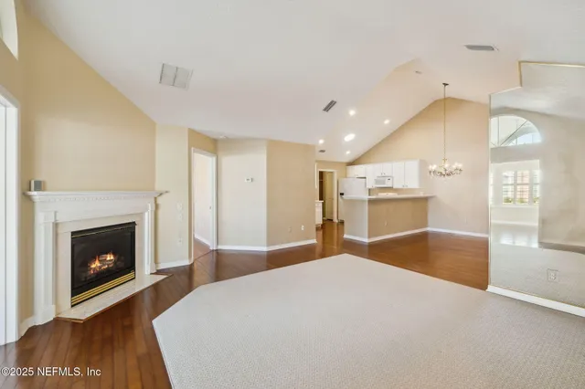 an empty room with wooden floor cabinet and windows