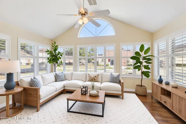 an empty room with wooden floor and ceiling fan