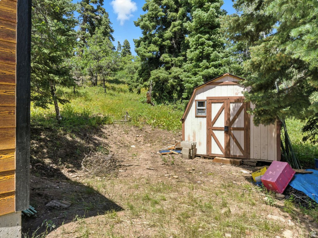 1180 Oak Road Coalville, UT 84017 - Photo 10 of 28 Detached storage shed with barn-style doors and a side window, surrounded by mature evergreen trees