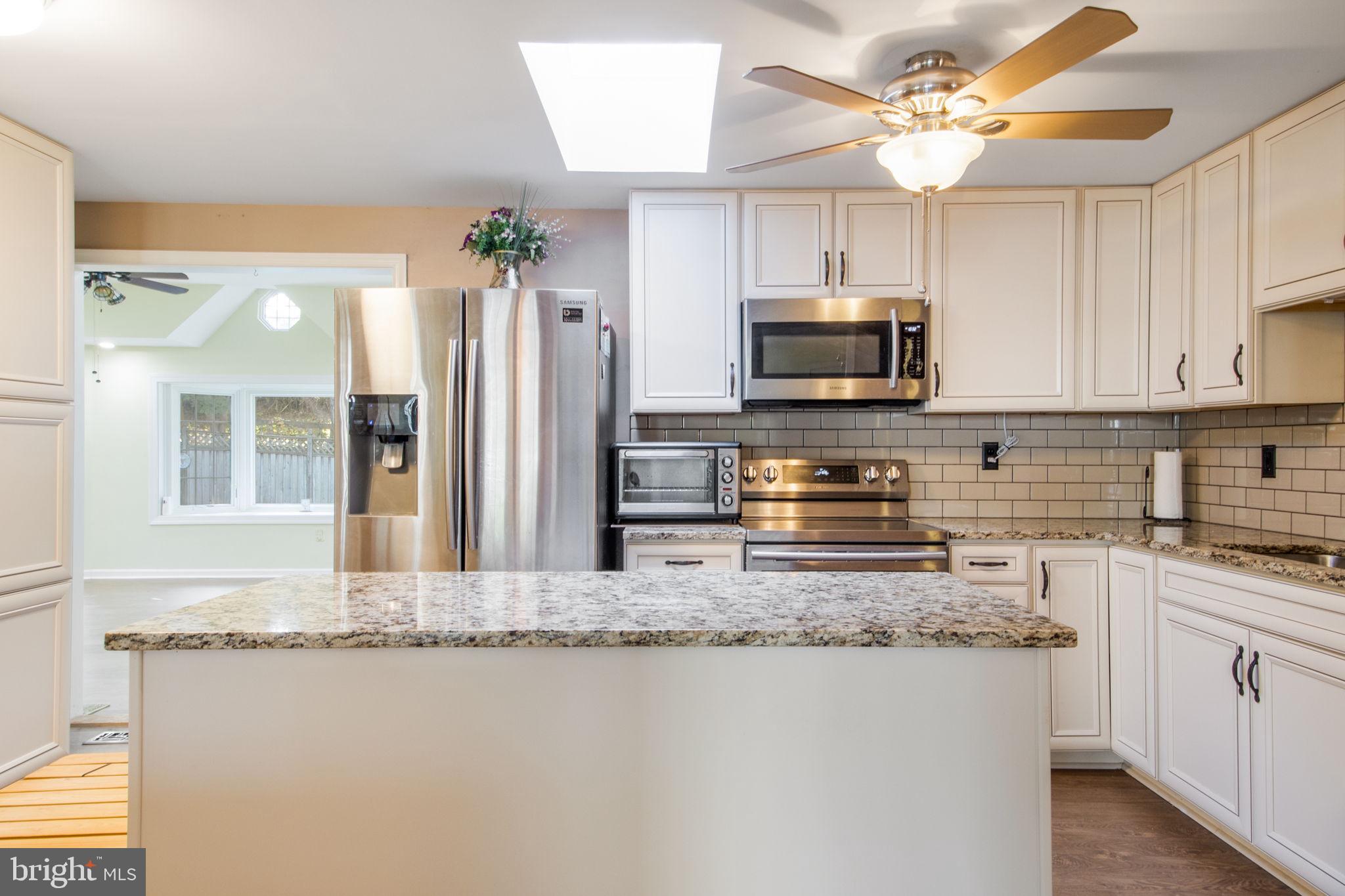 7316 Torran Rocks Way Gaithersburg, MD 20879 - Photo 2 of 17 a kitchen with stainless steel appliances granite countertop a stove top oven a refrigerator a sink and dishwasher