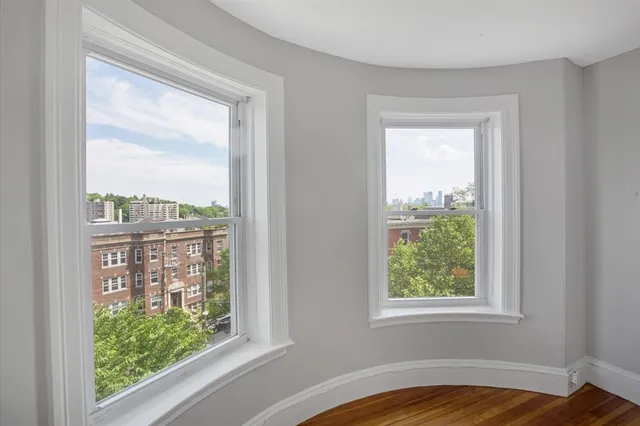 a view of a bedroom with wooden floor and a window