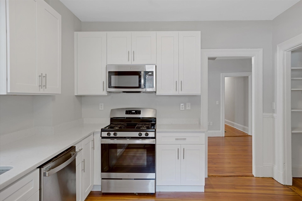 112 Winthrop Road, Unit 5 Brookline, MA 02445 - Photo 5 of 21 a kitchen with cabinets stainless steel appliances and wooden floor
