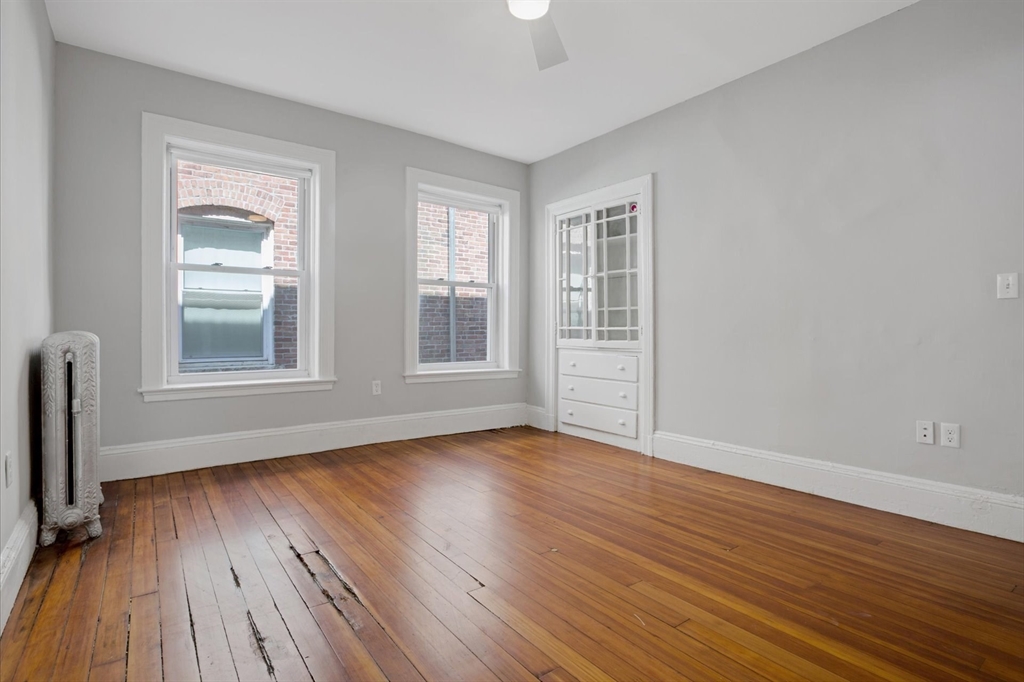 112 Winthrop Road, Unit 5 Brookline, MA 02445 - Photo 10 of 21 an empty room with wooden floor and windows