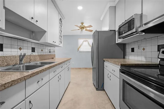 a kitchen with stainless steel appliances granite countertop a sink and a stove
