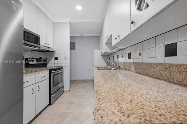 a kitchen with stainless steel appliances granite countertop a sink and a stove