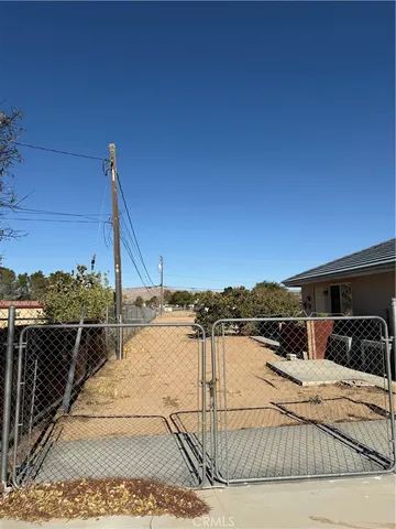 a backyard of a house with wooden fence and trees