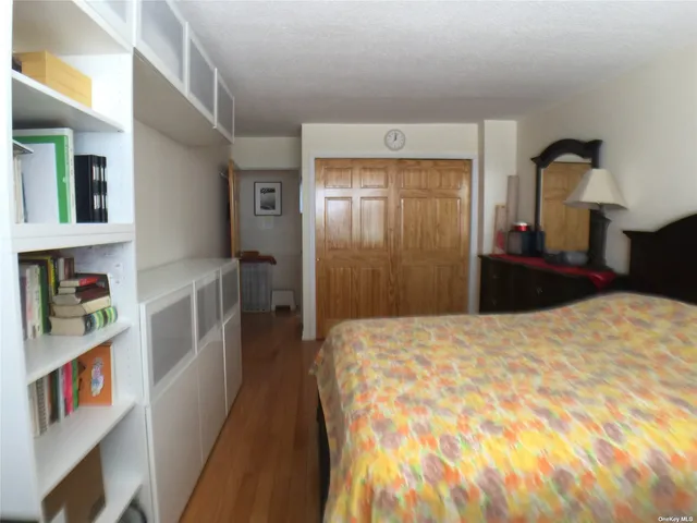 a bedroom with a bed and a large mirror on the dresser