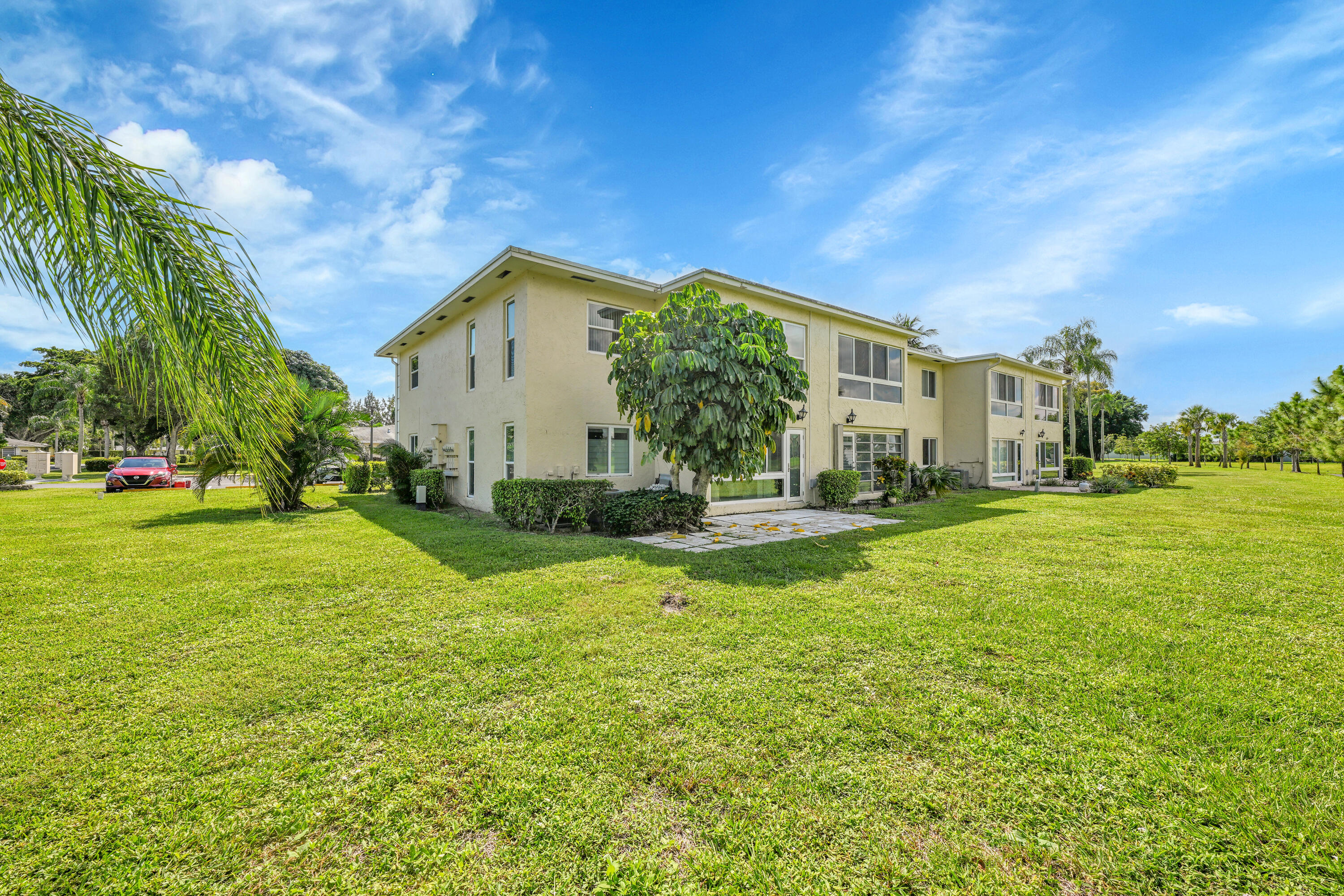 13791 Flora Place, Unit D Delray Beach, FL 33484 - Photo 3 of 24 a house view with swimming pool garden and trees