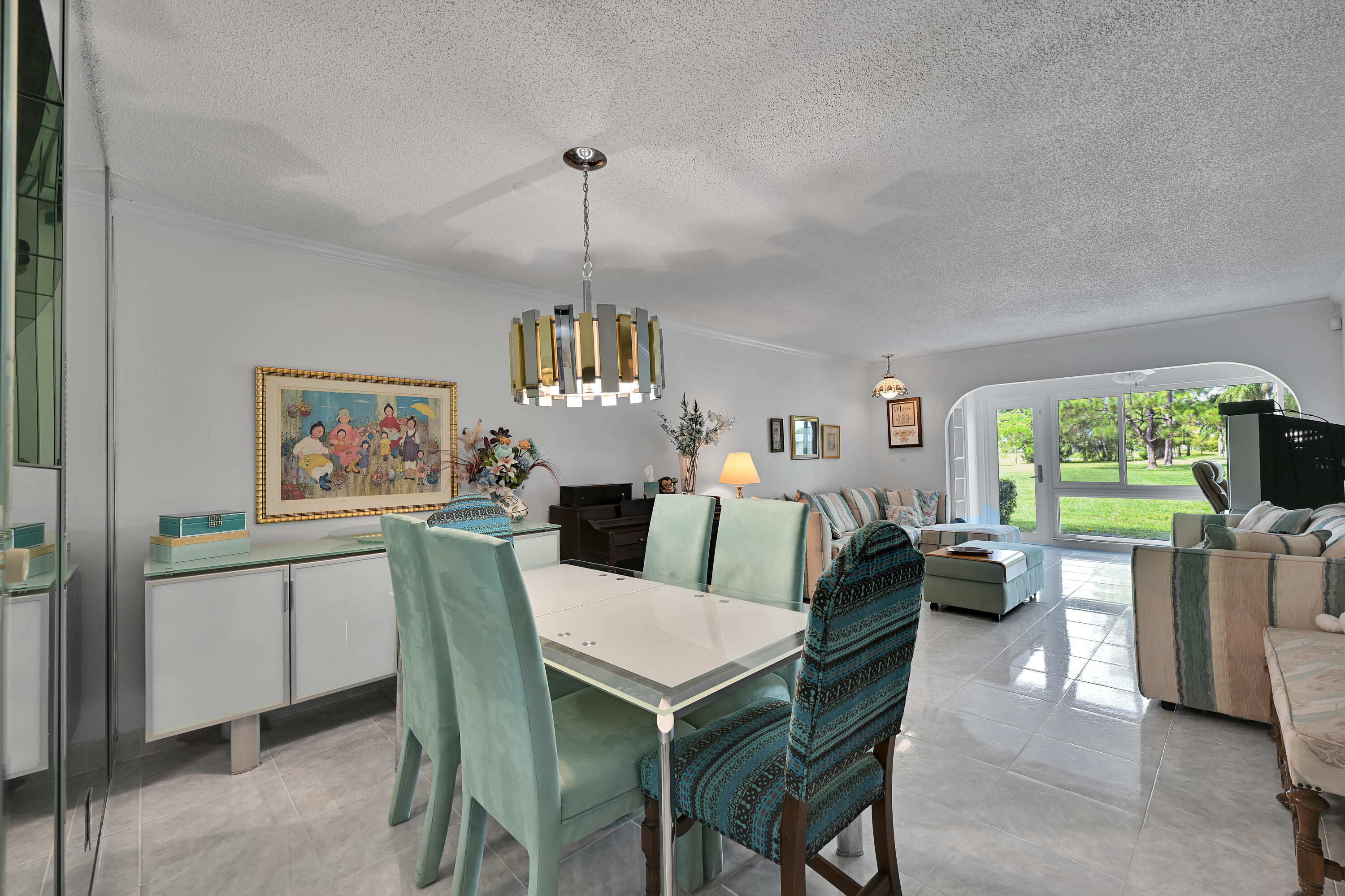 13791 Flora Place, Unit D Delray Beach, FL 33484 - Photo 8 of 24 a view of a dining room with furniture a livingroom and chandelier