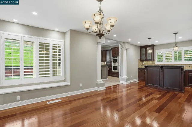 a view of a kitchen with granite countertop stainless steel appliances cabinets a sink and a counter top space