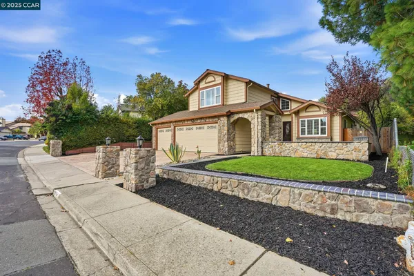a kitchen with stainless steel appliances granite countertop a sink a stove a refrigerator and a wooden cabinets