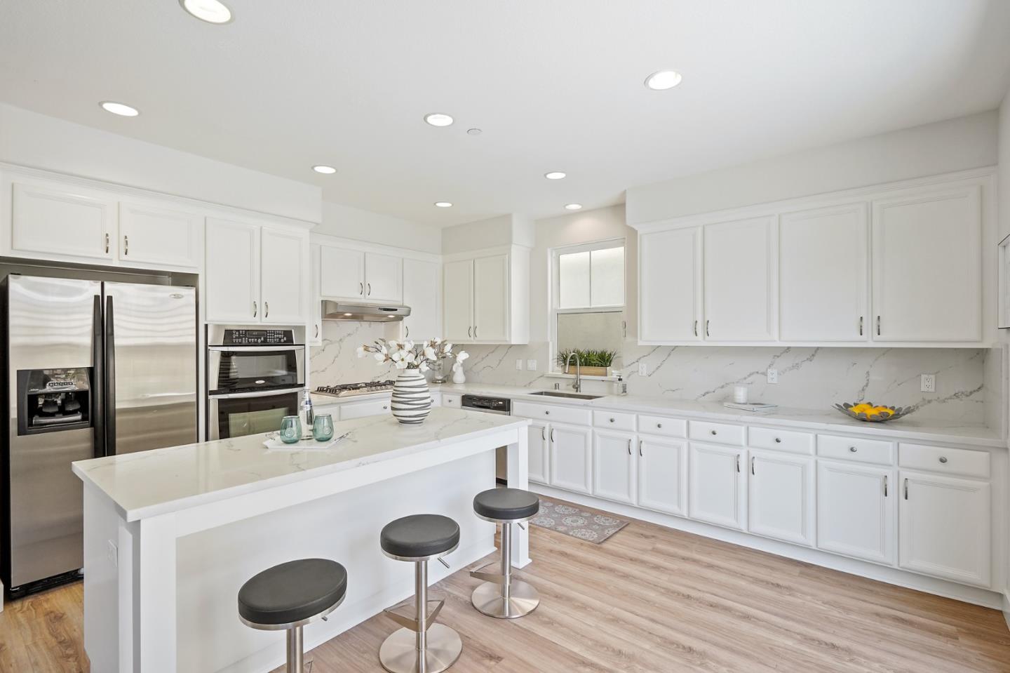 115 Cypress Street Pacifica, CA 94044 - Photo 14 of 59 a kitchen with granite countertop a sink stove refrigerator and white cabinets with wooden floor