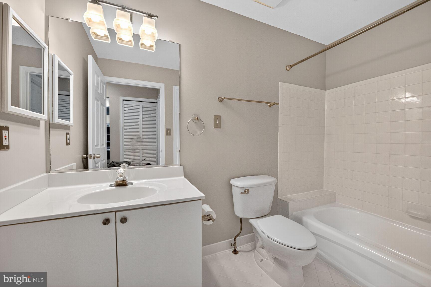 44084 Natalie Terrace, Unit 301 Ashburn, VA 20147 - Photo 12 of 15 a bathroom with a sink toilet a mirror and shower