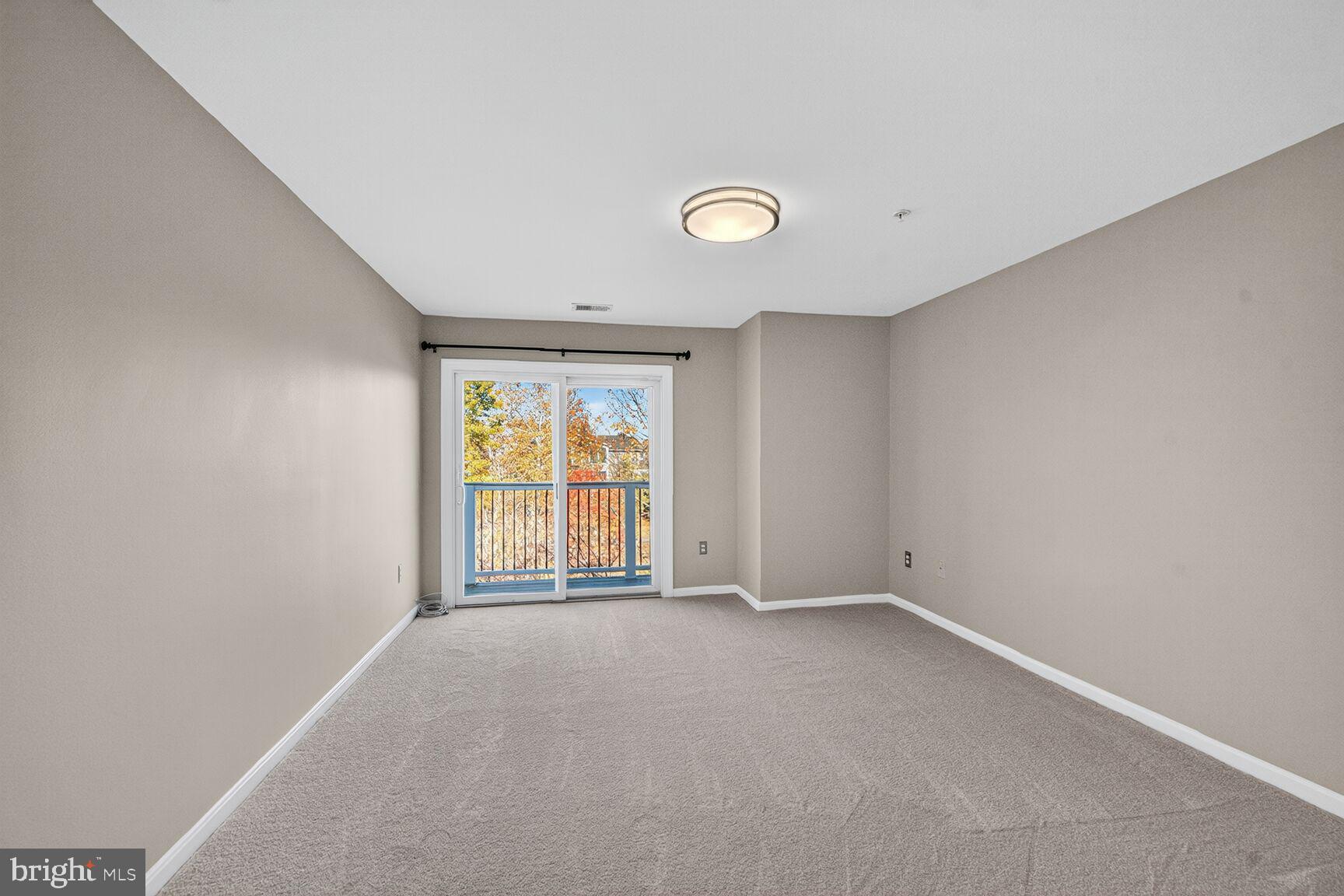 44084 Natalie Terrace, Unit 301 Ashburn, VA 20147 - Photo 4 of 15 an empty room with windows