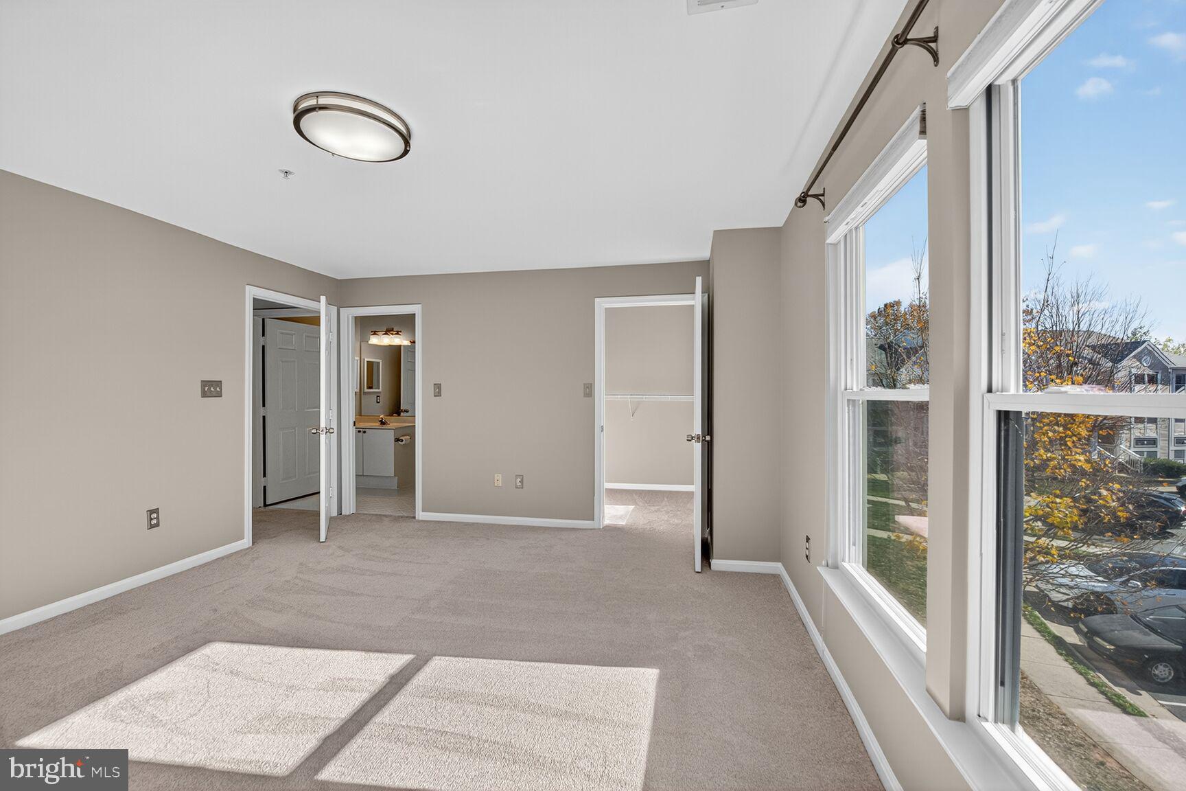 44084 Natalie Terrace, Unit 301 Ashburn, VA 20147 - Photo 6 of 15 a view of empty room with wooden floor and windows