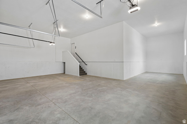 728 East Mountain Road North Ogden, UT 84414 - Photo 17 of 28 Spacious garage featuring a concrete floor, bright white walls, recessed lighting, and a built-in staircase with a handrail