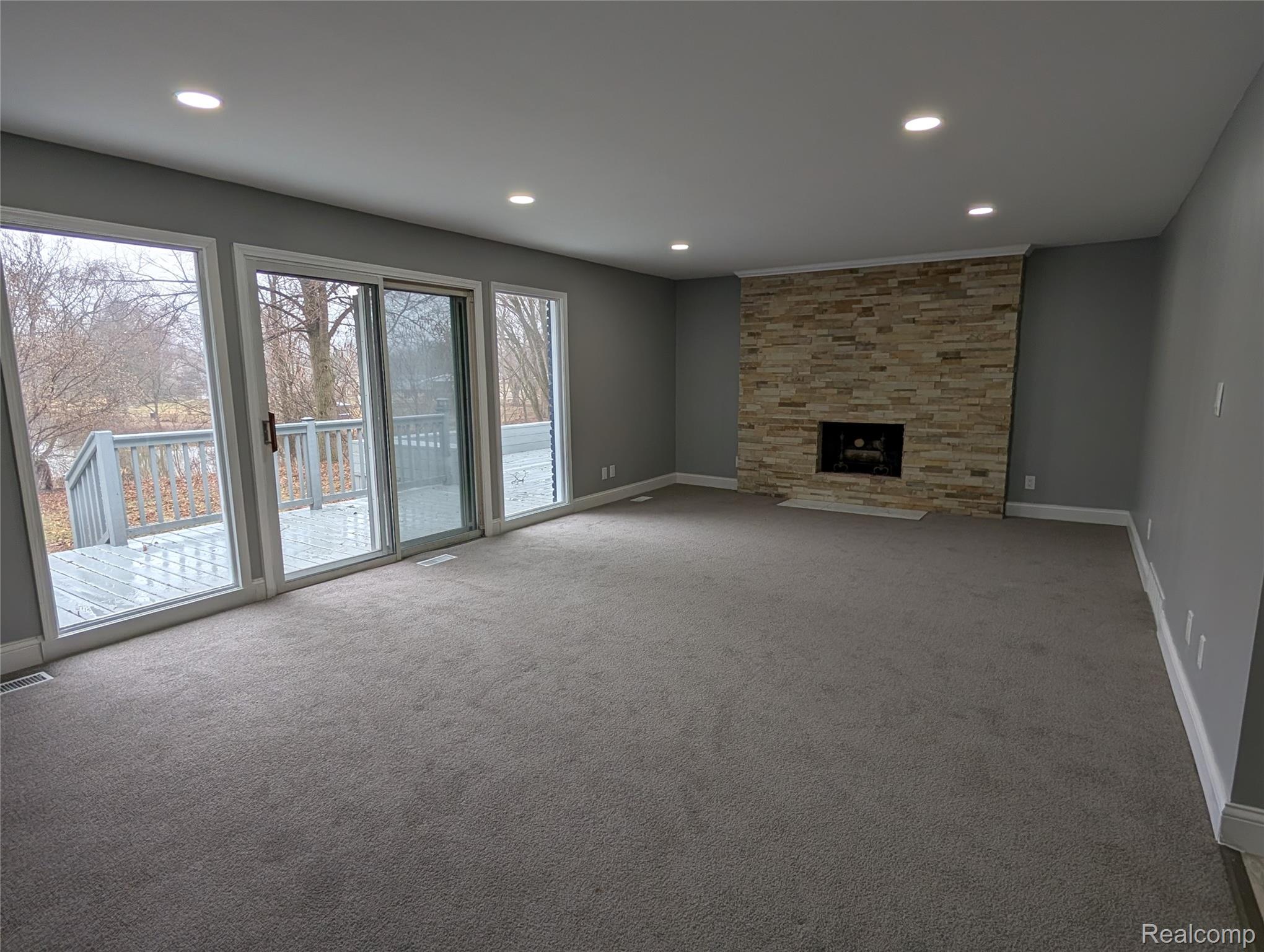 6353 Perry Road Grand Blanc, MI 48439 - Photo 8 of 34 Living room with gas fireplace. Doorwall to deck overlooking water.
