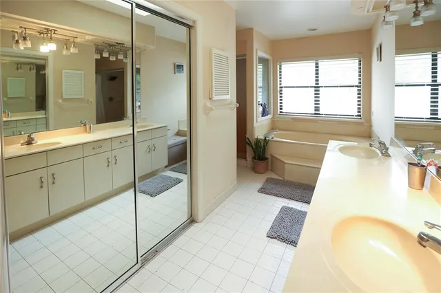 a bathroom with a tub sink and mirror