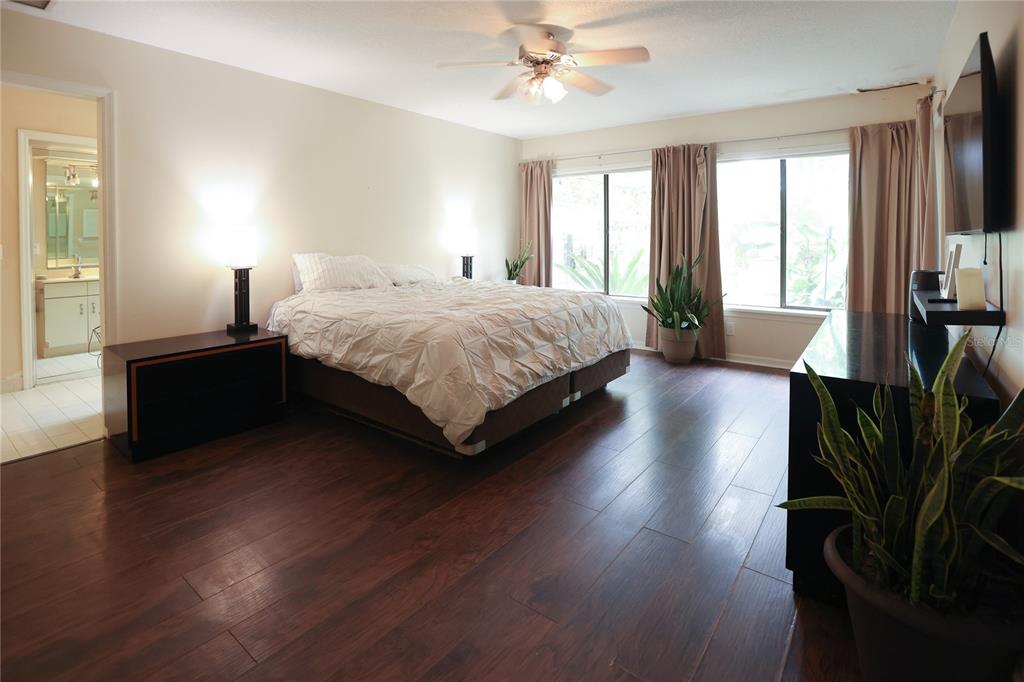 11923 Lake Butler Boulevard Windermere, FL 34786 - Photo 21 of 31 a spacious bedroom with a bed and a flat tv screen on dresser