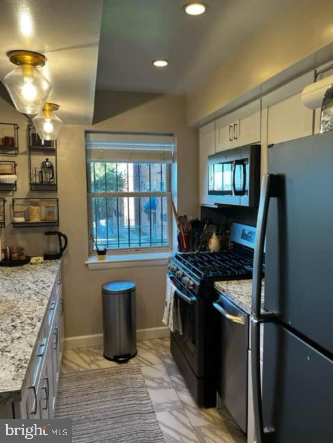 2655 Birney Place Southeast, Unit 101 Washington, DC 20020 - Photo 5 of 33 a kitchen with granite countertop a stove and a sink