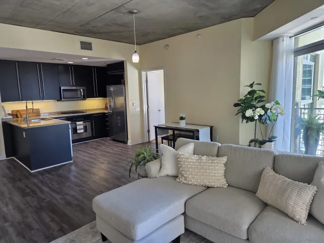 a living room with furniture kitchen view and a potted plant