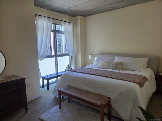 a bedroom with a bed a mirror and a window