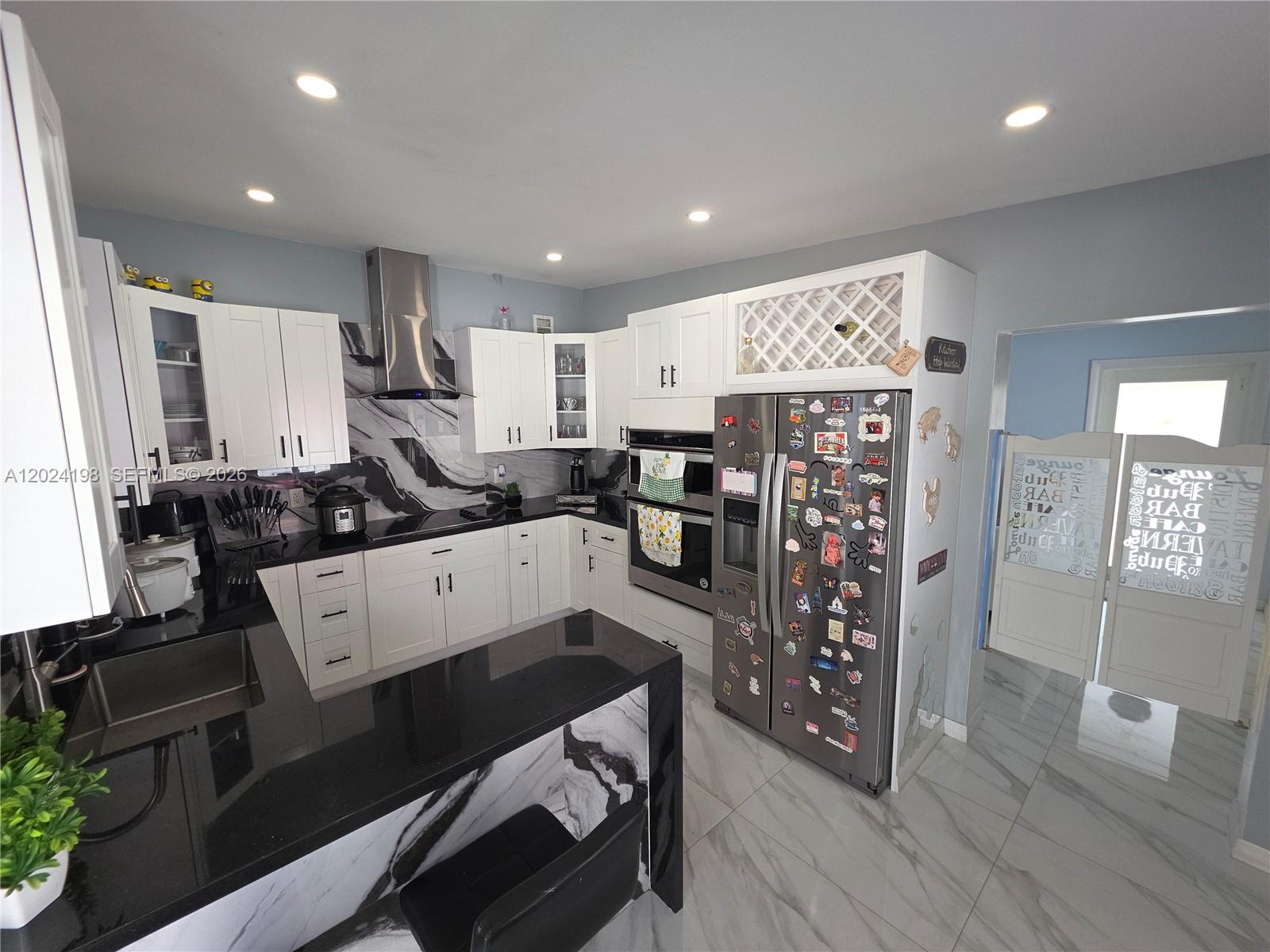 651 East 48th Street Hialeah, FL 33013 - Photo 15 of 52 a large white kitchen with stainless steel appliances granite countertop a stove a sink a refrigerator and a microwave