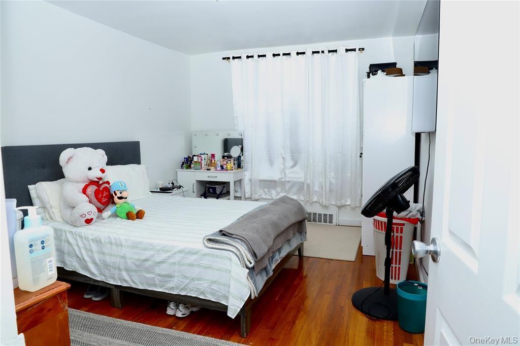 150-29 72nd Road, Unit 5C Queens, NY 11367 - Photo 11 of 34 a bedroom with a bed and a chandelier