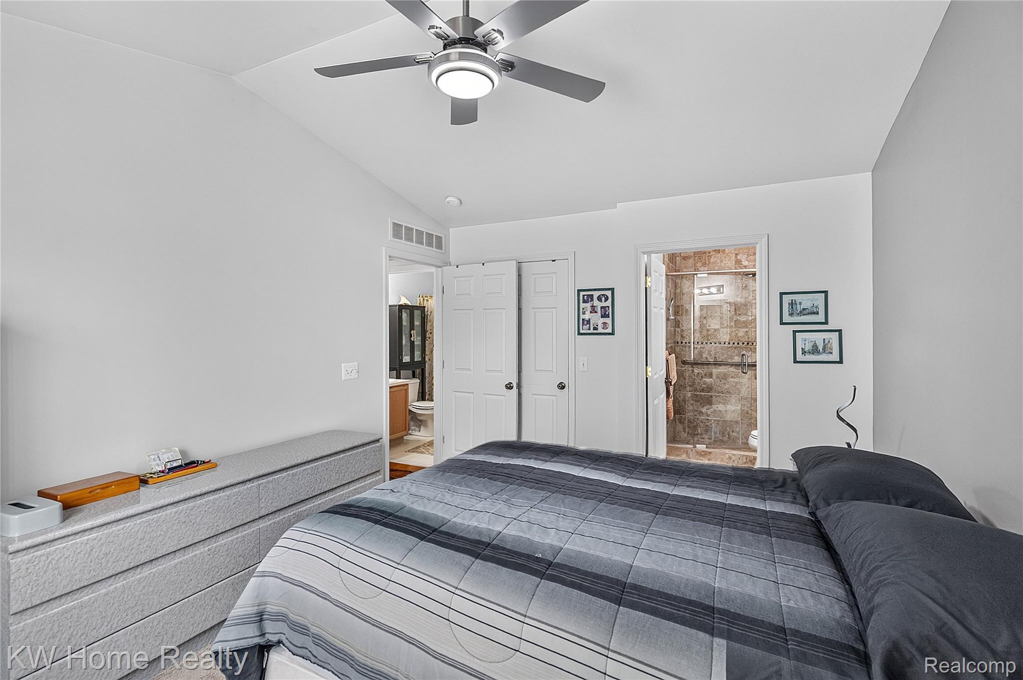 3216 High Pointe Ridge Road Lake Orion, MI 48359 - Photo 15 of 24 Vaulted ceiling with a flush-mount ceiling fan and integrated lighting, dual closet doors, and an en-suite bathroom featuring a walk-in shower with textured tile surround