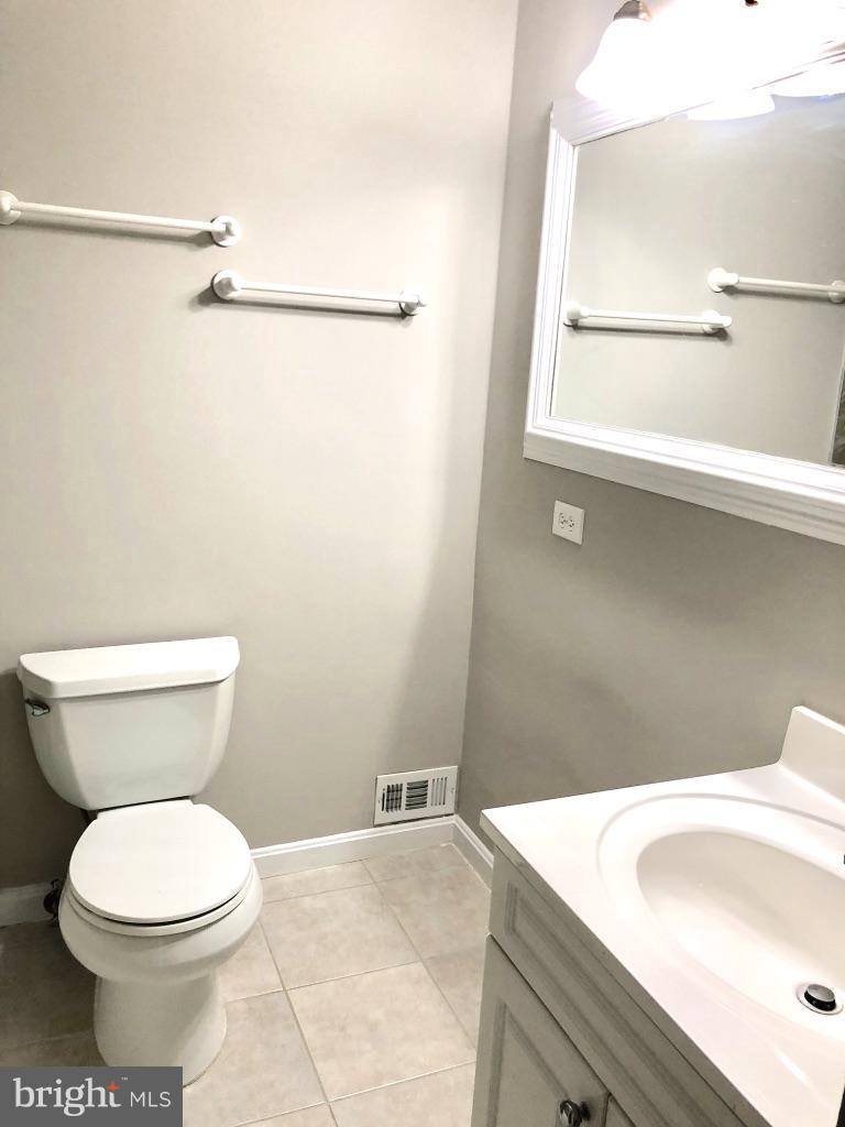 581 Summit Hall Road Gaithersburg, MD 20877 - Photo 14 of 22 a bathroom with a sink a toilet and a mirror