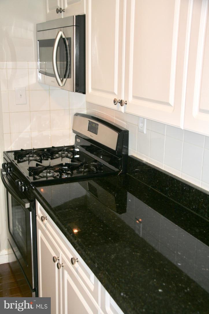 581 Summit Hall Road Gaithersburg, MD 20877 - Photo 6 of 22 a kitchen with granite countertop cabinets and a stove top oven