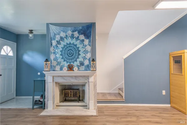 a living room with a fireplace and wooden floor