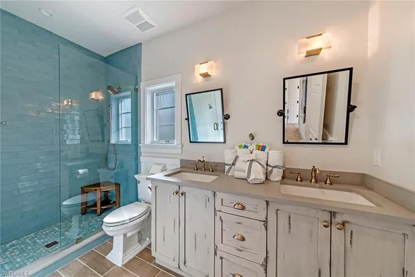 a bathroom with a granite countertop toilet sink and mirror