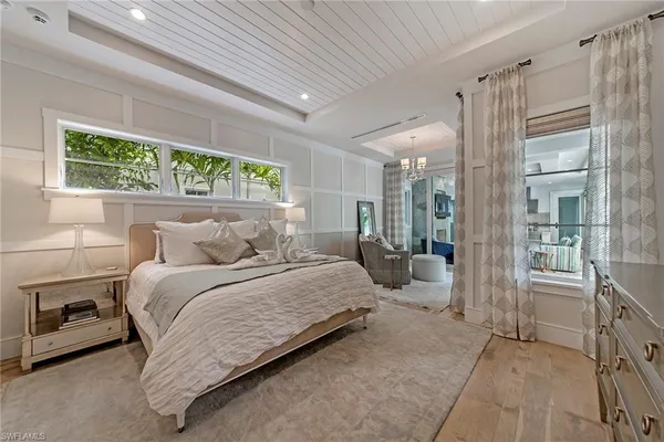 a bedroom with a bed mirror and a window