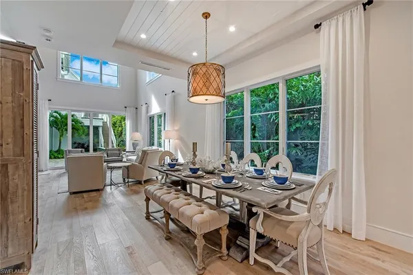 a dining room with wooden floor table and chairs