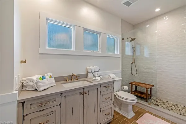 a bathroom with a granite countertop toilet sink and mirror