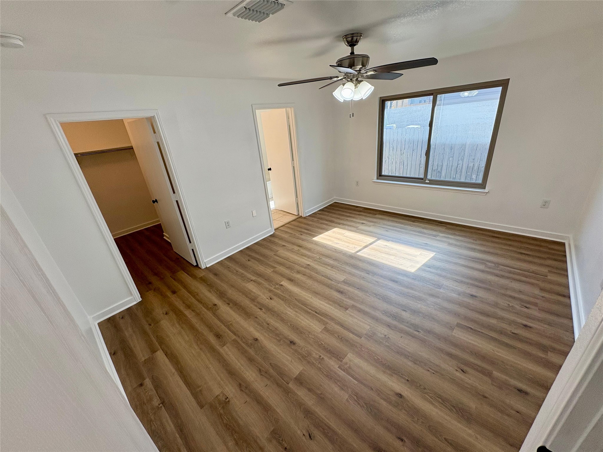 8003 Bannock Lane Austin, TX 78747 - Photo 18 of 40 Master bedroom with a spacious closet, light wood finished floors, and ceiling fan