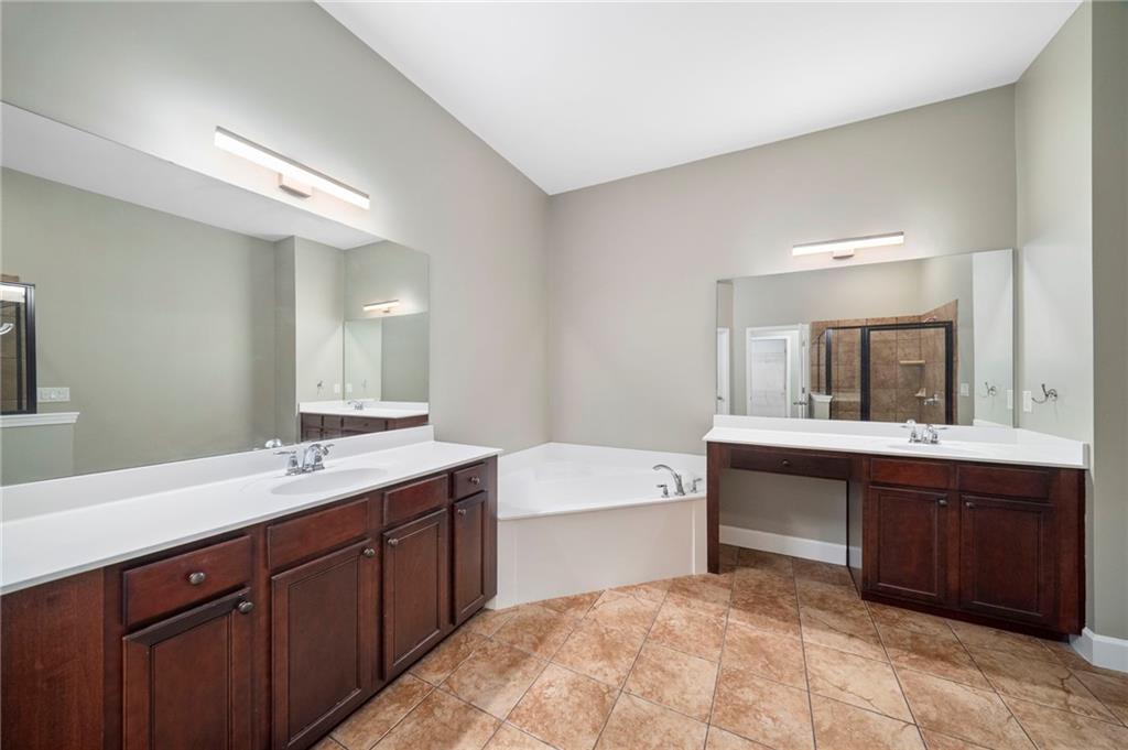 3628 Ashcroft Bend Atlanta, GA 30319 - Photo 28 of 44 a spacious bathroom with a sink double vanity granite tub and a mirror
