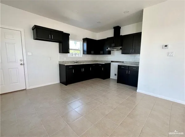 a large kitchen with a stove a sink and a refrigerator