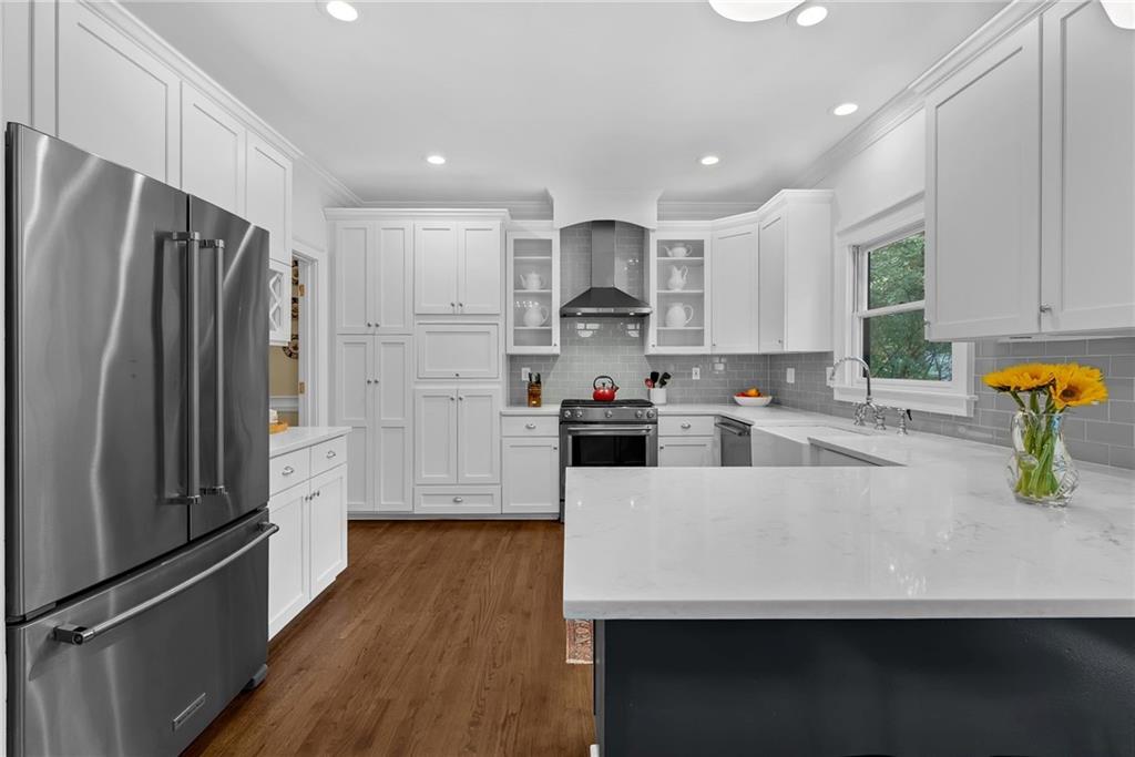 411 Chelsea Circle Northeast Atlanta, GA 30307 - Photo 19 of 42 a kitchen with stainless steel appliances a refrigerator sink and white cabinets