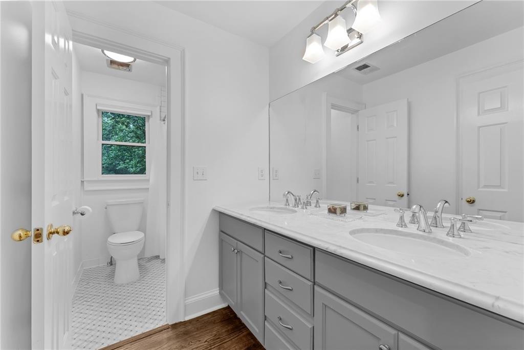 411 Chelsea Circle Northeast Atlanta, GA 30307 - Photo 32 of 42 a bathroom with a double vanity sink toilet and a mirror