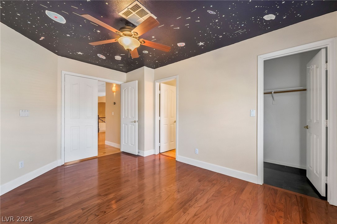 271 Pointe Ranier Avenue Henderson, NV 89012 - Photo 13 of 26 This spacious bedroom features lustrous hardwood flooring, ample natural light, and convenient access to the hallway.